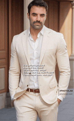 a man in a white suit is standing in front of a building with his hands in his pockets ..