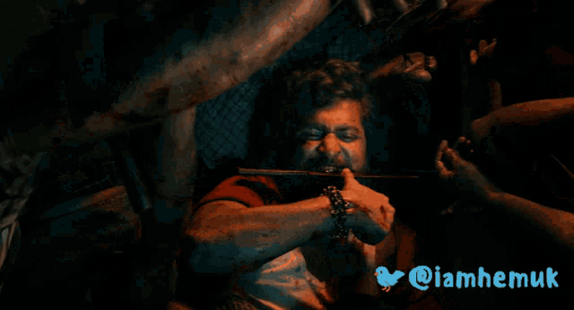 a man with a knife in his mouth and the hashtag @iamhemuk on the bottom