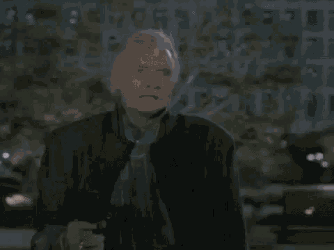 a person is walking down a street at night with a huge explosion in the background .
