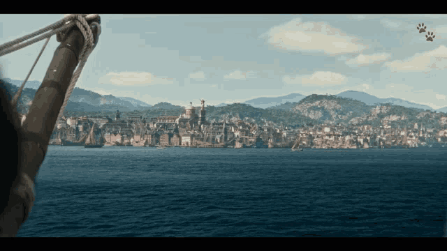 a large body of water with mountains in the background and a city in the distance