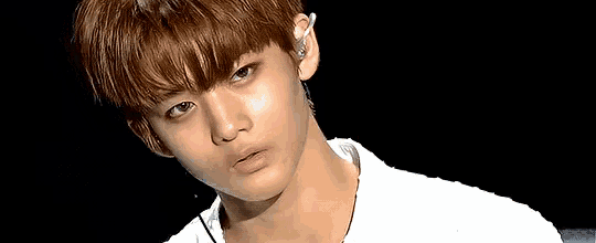 a close up of a young man 's face with a white shirt on .