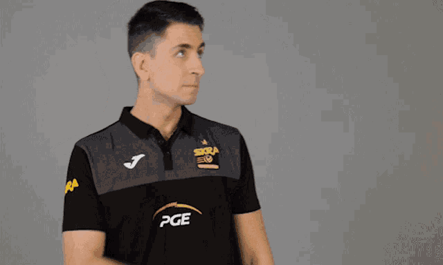 a man wearing a black shirt with pge on the front