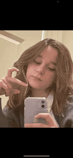 a young girl is taking a selfie with her iphone