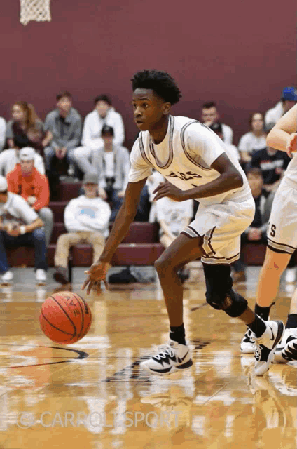 a basketball player dribbles the ball while wearing a white jersey with the number 1 on it