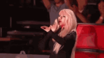 a woman blows a kiss in front of a crowd