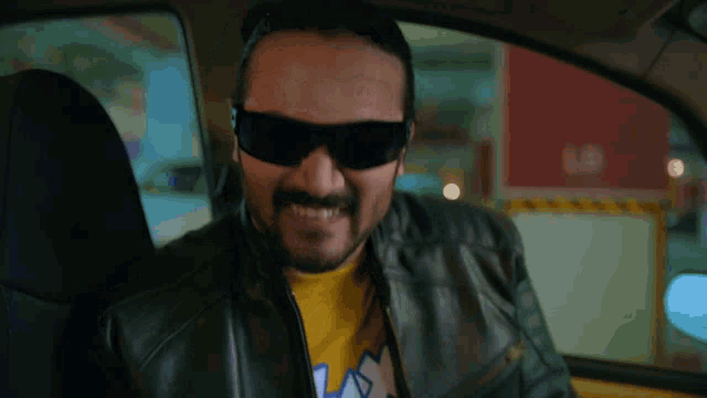 a man wearing sunglasses and a yellow shirt that says ' lax ' on it