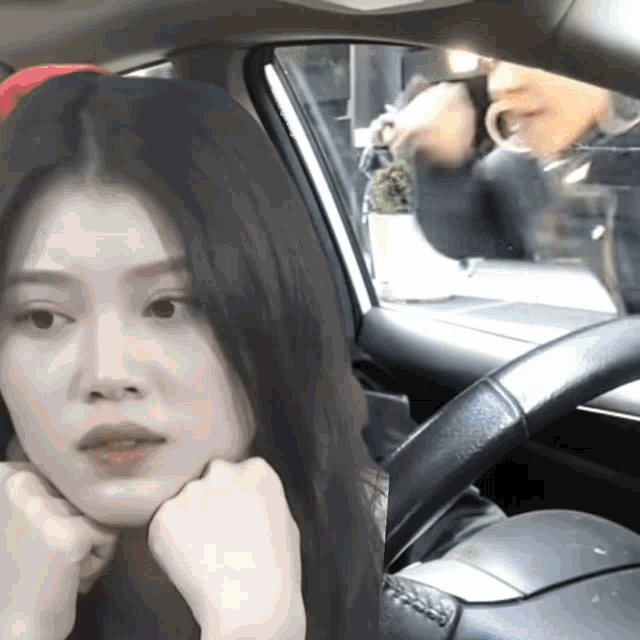 a woman sitting in a car looking at the camera