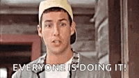 a man wearing a hat and a jacket is standing in front of a door and says `` everyone is doing it ! ''