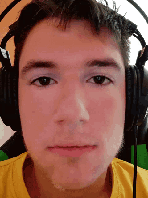a man wearing headphones looks at the camera