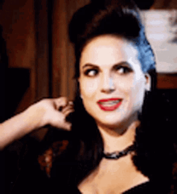 a close up of a woman 's face with red lips and a bun .