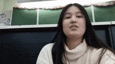 a woman with long hair wearing a white turtleneck sweater