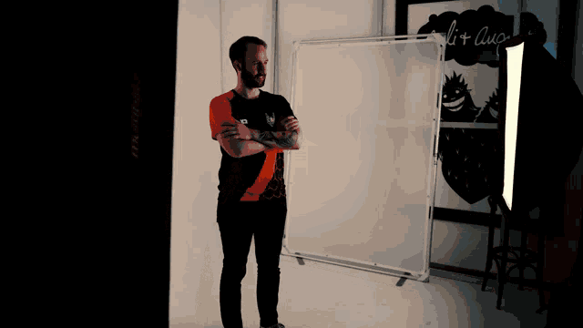 a man with his arms crossed stands in front of a white board that says " lit " on it