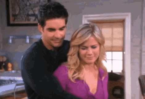 a man and a woman are hugging in a kitchen