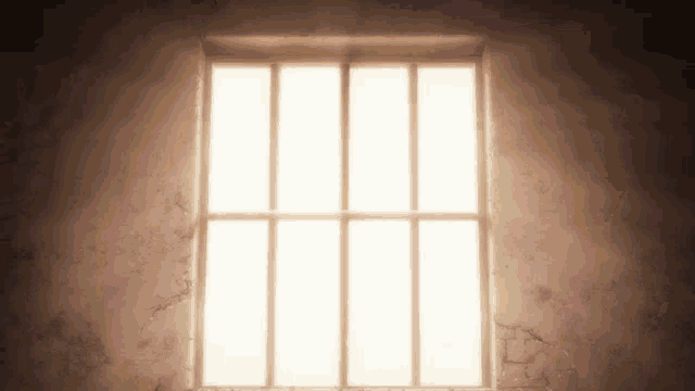 a prison cell with a window with bars on it