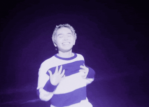 a man wearing a blue and white striped shirt is dancing