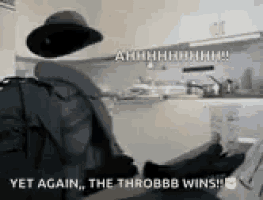 a man in a hat is standing in a kitchen with the words `` yet again , the throbb wins ! ''