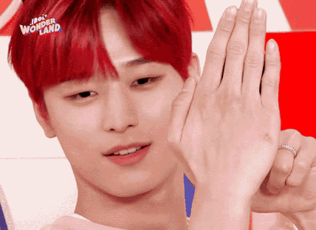 a young man with red hair and a ring on his finger