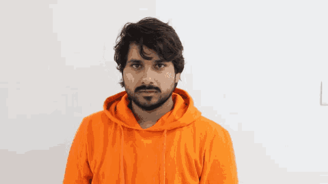 a man with a beard wearing a bright orange hoodie