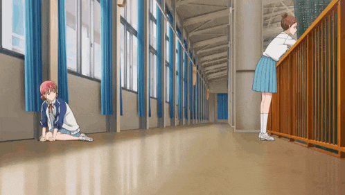 two girls are standing next to each other in a hallway in a school .