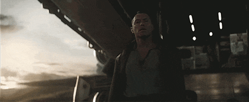a man is standing in the dark in front of a large object .