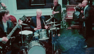 a group of men are playing instruments including drums