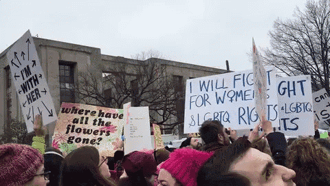 a group of people holding up signs including one that says i will fight for women