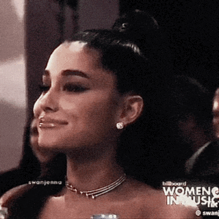 ariana grande is wearing a necklace and smiling at the women 's music awards