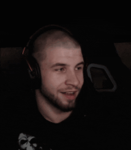 a man wearing headphones is smiling and looking at the camera .
