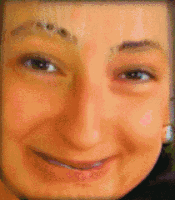 a close up of a woman 's face with a slight smile on her face