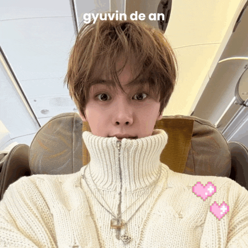 a person wearing a white sweater with the word gyuvin de an on top