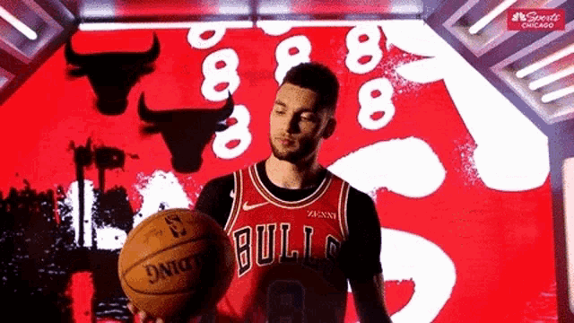 a man in a bulls uniform is holding a basketball .