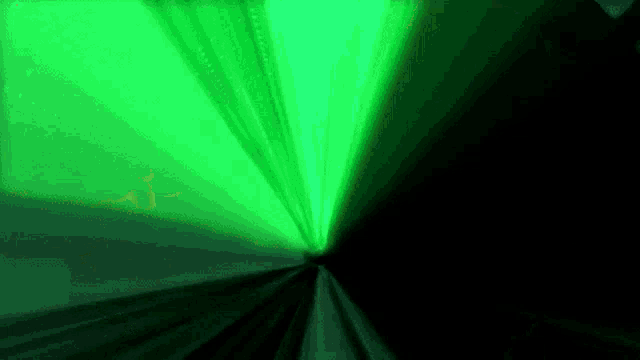a green light is coming out of a dark tunnel