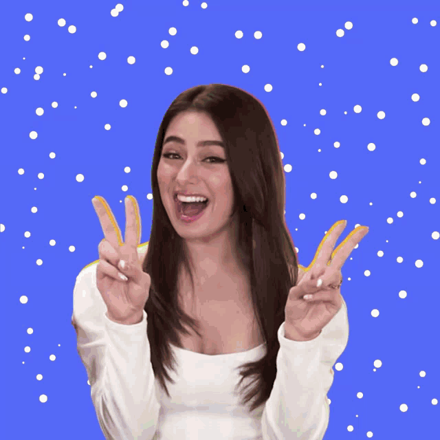 a woman giving a peace sign in front of a rainbow background