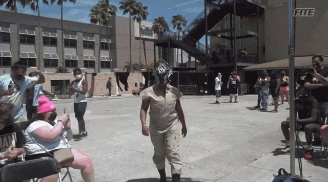 a woman wearing a mask stands in front of a building that says fite