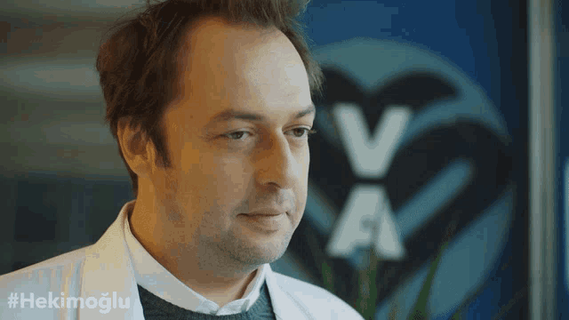 a man in a white lab coat stands in front of a logo that says va