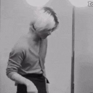 a black and white photo of a person standing in front of a mirror with the letters tc on the bottom