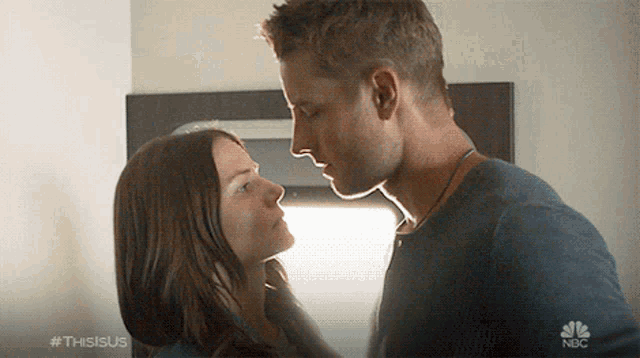 a man and a woman are looking into each other 's eyes with a nbc logo in the background