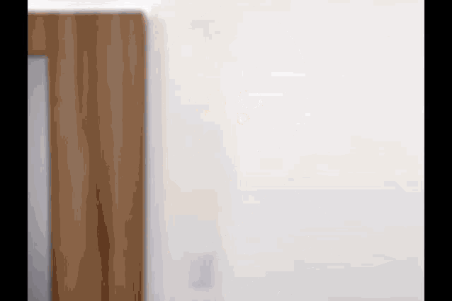 a close up of a door with a white wall in the background