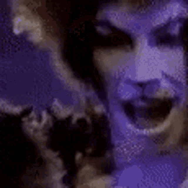 a close up of a person 's face with a purple background and a purple light behind them .