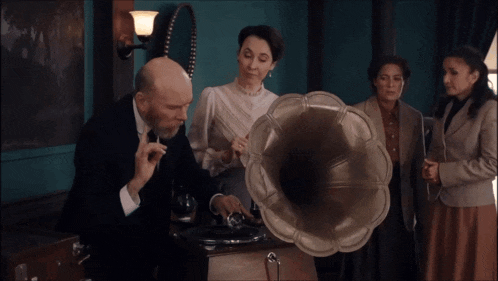 a group of people standing around a gramophone