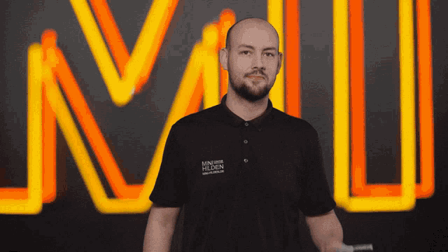 a man stands in front of a neon sign that says n