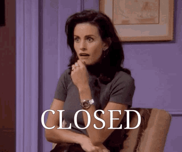 a woman is sitting in a chair with the word closed above her