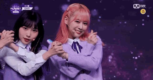 two girls are posing for a picture and one has pink hair and the other has black hair