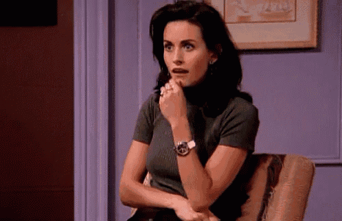a woman wearing a watch is sitting in a chair in front of a purple wall