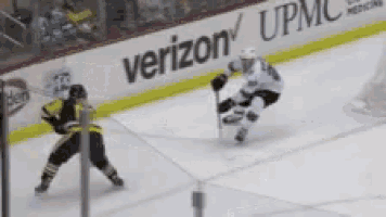 a hockey game is being played in front of an ad for verizon