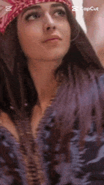 a close up of a woman wearing a bandana looking up