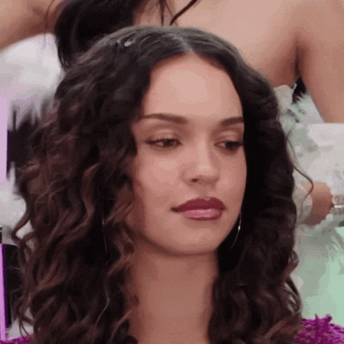 a woman with curly hair is getting her hair styled