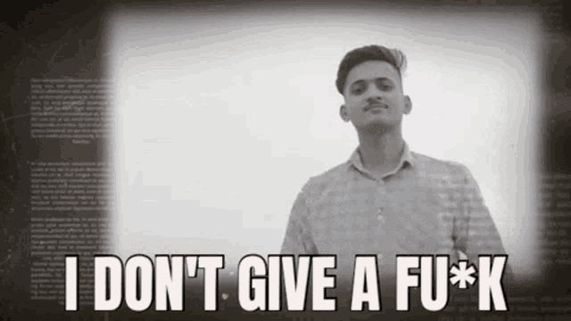 a man is standing in front of a screen that says i do n't give a fu * k