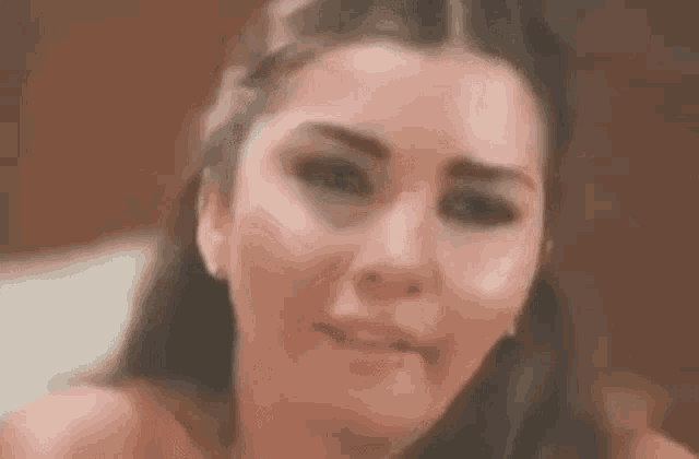 a close up of a woman 's face with a tear running down her cheek .
