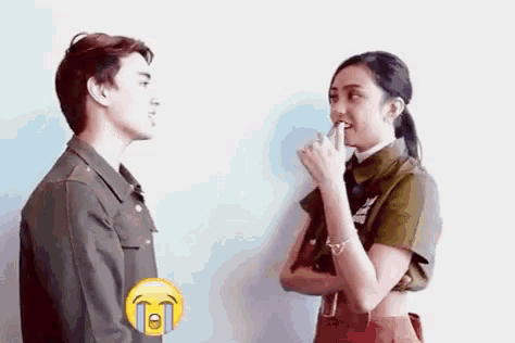 a man and a woman are standing next to each other and talking to each other . the woman is crying .